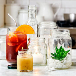 Seven Ways to Reuse Our Jars | Various sized recycled glass jars filled with iced tea, plants, food, candles