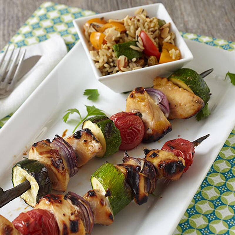 A plate of grilled chicken and vegetable skewers.